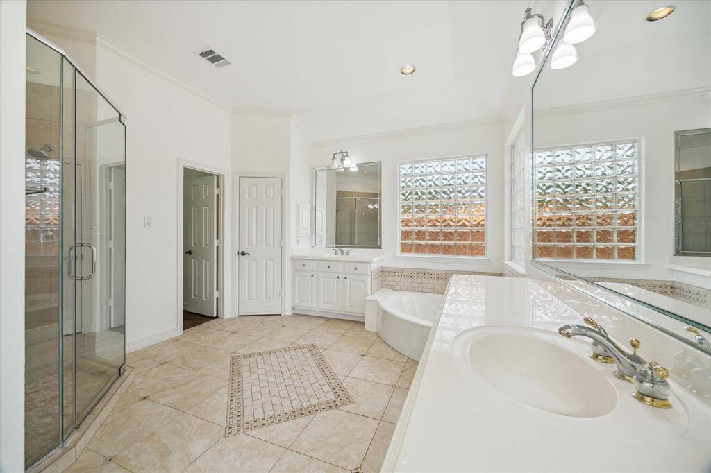 Alternate angle of the Primary Bathroom with a view of the stand up shower looking towards the closet.