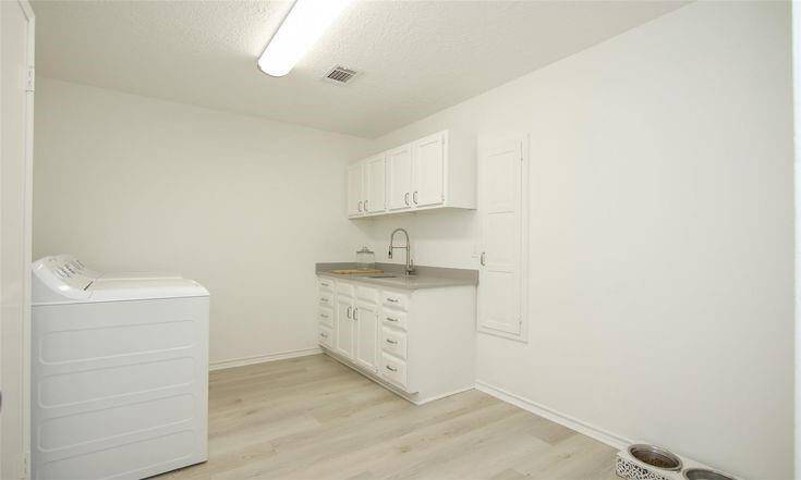 Full Laundry Room ViewPlenty of workspace and cabinetry for laundry and storage needs.