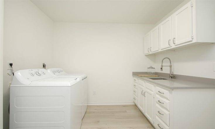 Laundry with Built-insGenerously sized utility room with storage cabinets and sink.