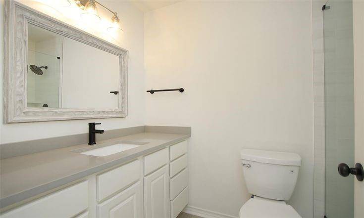 Hall BathroomUpdated guest bath with extended quartz vanity and framed mirror.