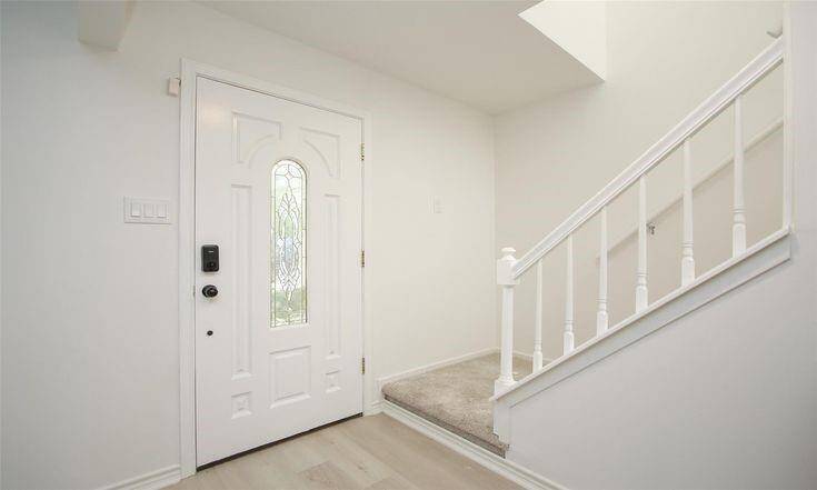 FoyerBright entry with decorative front door and access to upstairs.