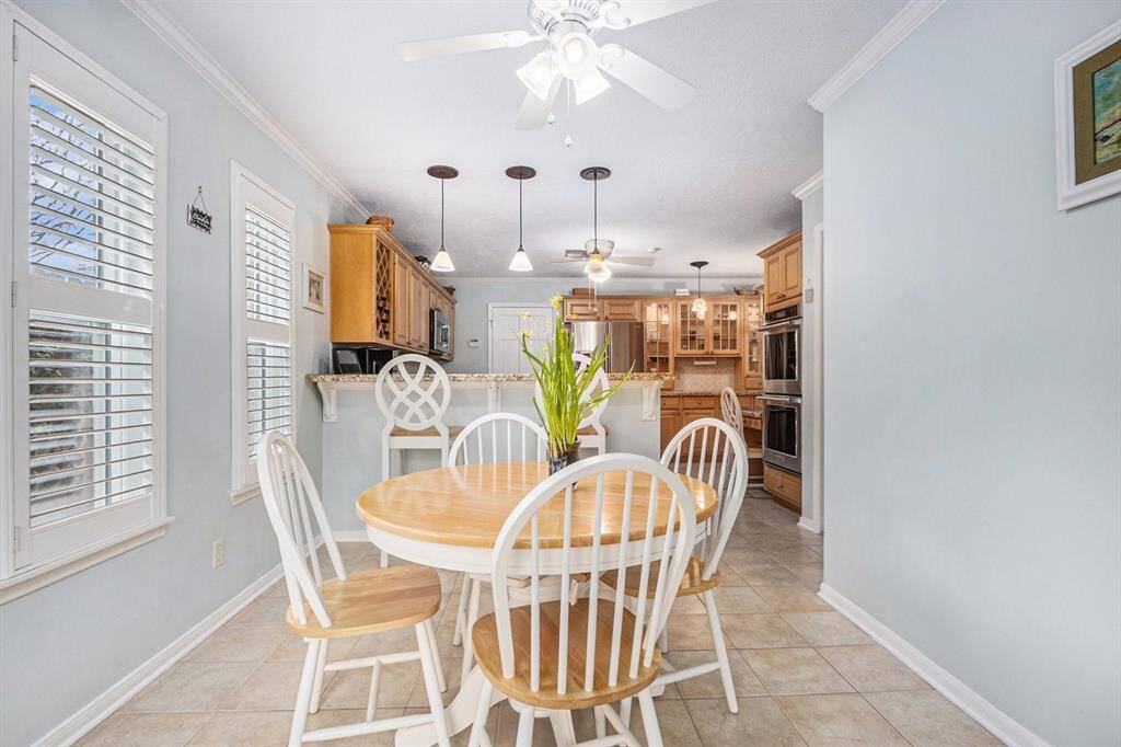 Breakfast room flows into the updated kitchen featuring a breakfast bar with pendant lighting for informal dining.