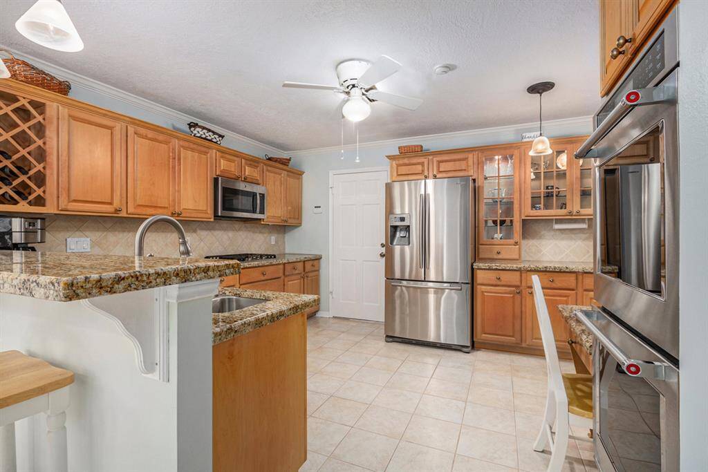 Granite countertops, double ovens, built in china cabinet with glass front enhanced by pendant lighting offers additional storage and counter space for the chef in the family.