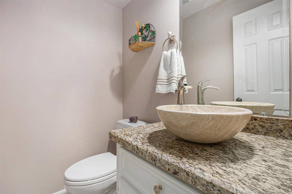 Powder room off the front foyer has recently been updated with modern sink and faucet.