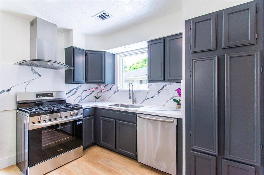 Stylish marble-patterned backsplash and a large window offering natural light.