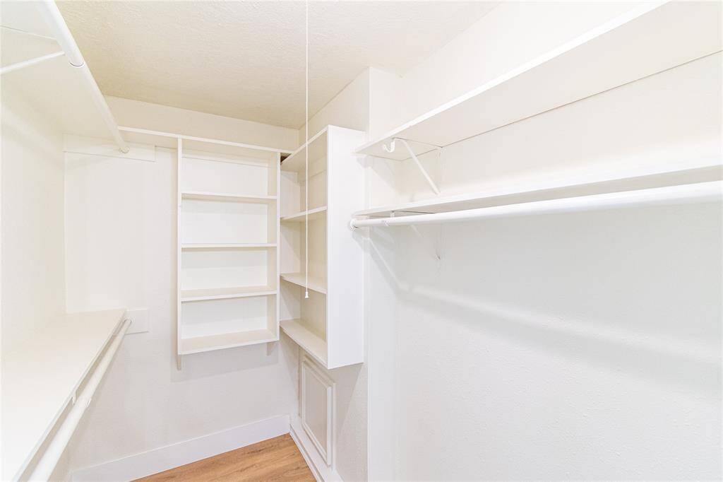Primary bedroom walk-in closet with ample shelving and hanging space.