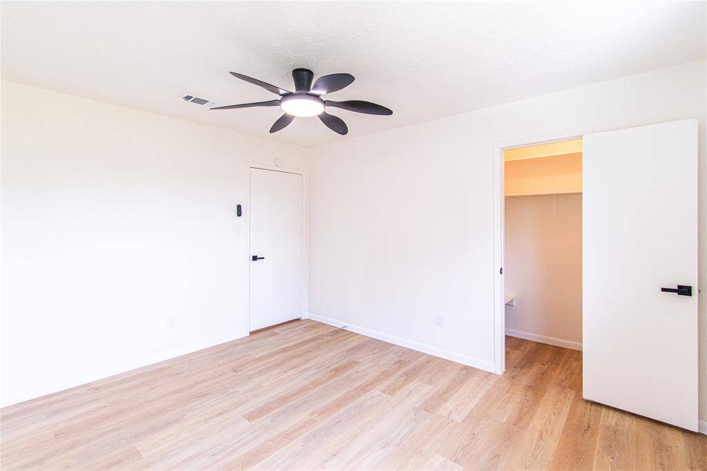 Bedroom 4 featuring modern flooring, a sleek ceiling fan, and ample closet space.