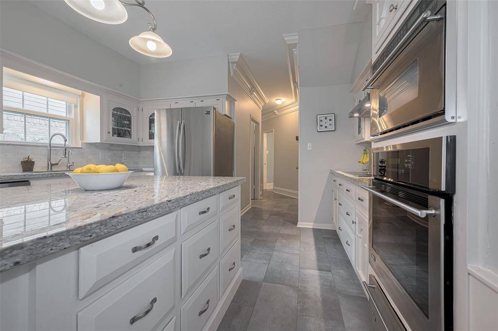 Equipped with stainless steel appliances and abundant drawer storage, this kitchen combines style and practicality. Beautiful tile flooring flows seamlessly throughout, adding a cohesive and elegant foundation to the space.
