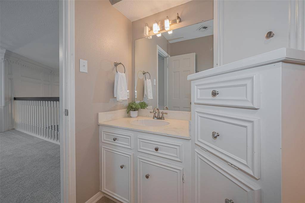 The upstairs guest bathroom features dual vanities, each with its own sink, providing convenience and personal space. Ample storage ensures everything stays neatly organized and within reach.