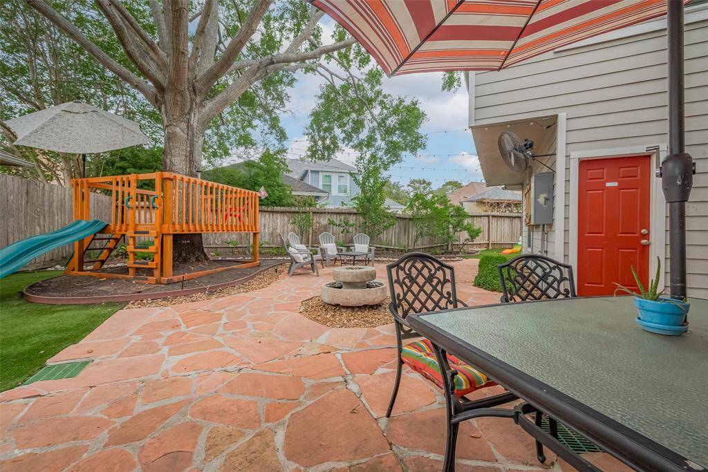Nestled among the towering backyard tree, a built-in treehouse with a slide offers a whimsical retreat that’s sure to delight children and spark imaginative play.