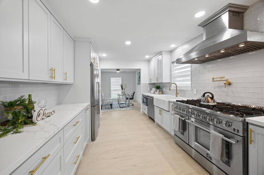 Featuring a premium 8-burner, 48” gas range, double fridge, and double ovens—this kitchen was made to impress.
