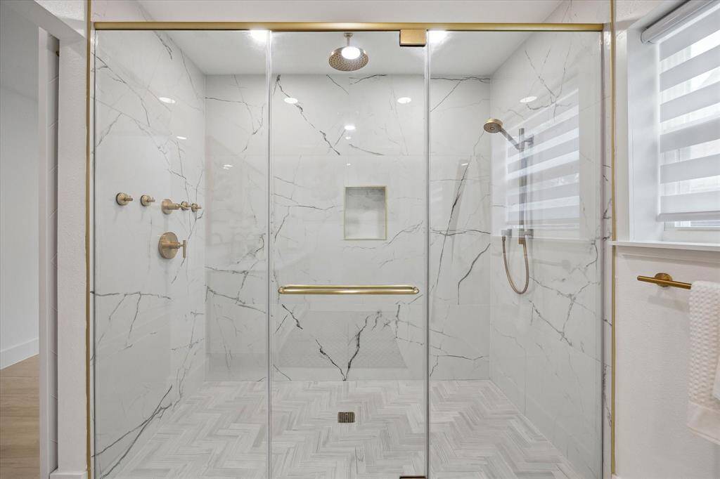 The spa-like primary bathroom boasts a luxurious walk-in shower with double shower heads for ultimate comfort.