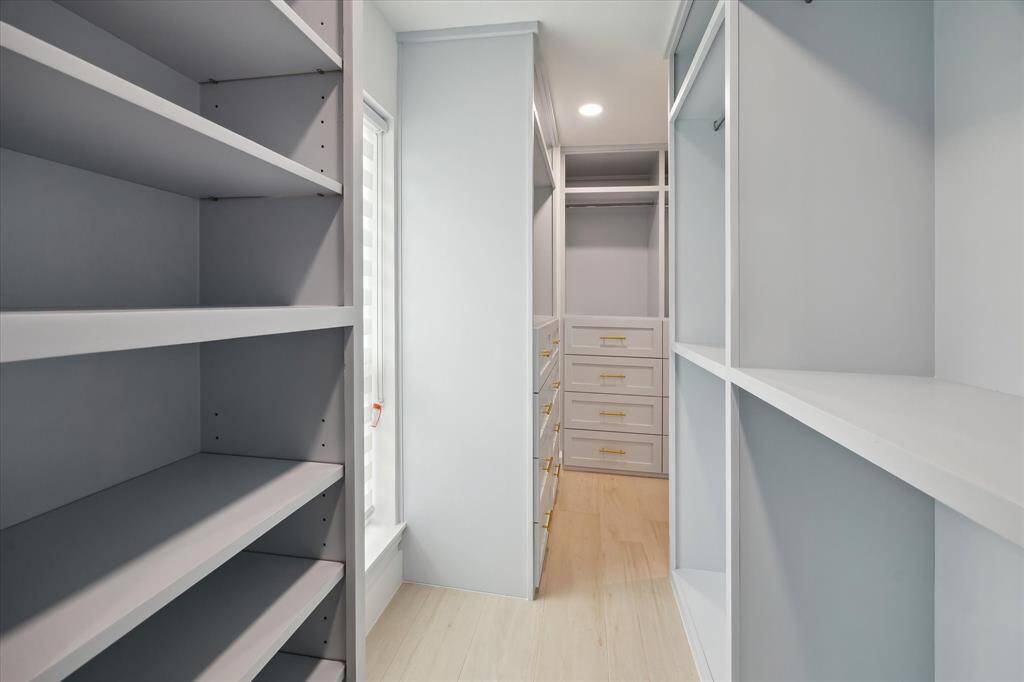 An expansive primary walk-in closet with custom built-ins offers abundant space and organization.