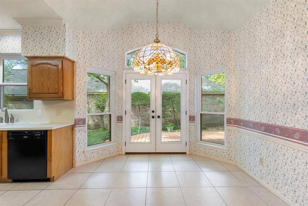 Light filled breakfast nook with large windows and double doors invites natural light and provides a peaceful view of the patio and garden.