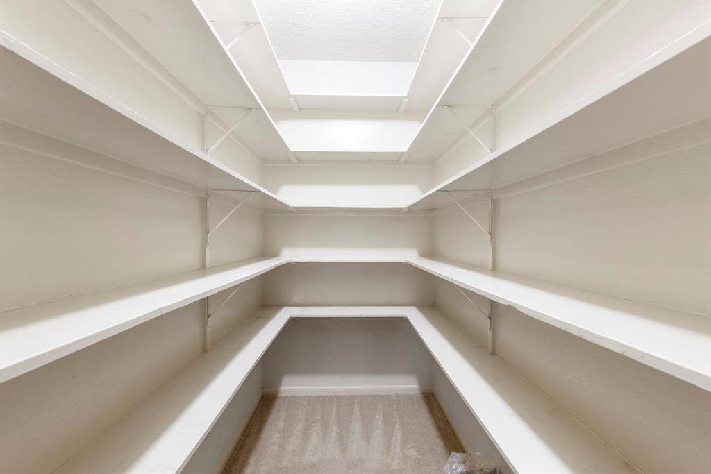This extra-large hall closet across from the primary suite offers extensive built-in shelving, perfect for linen storage, seasonal items, or overflow essentials.
