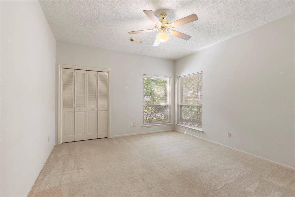 The secondary bedroom offers great natural light, a ceiling fan, and a full-size closet—perfect for guests or family.