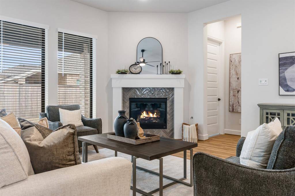 Another view of the family room with gas log fireplace, tall windows and hall to primary suite.