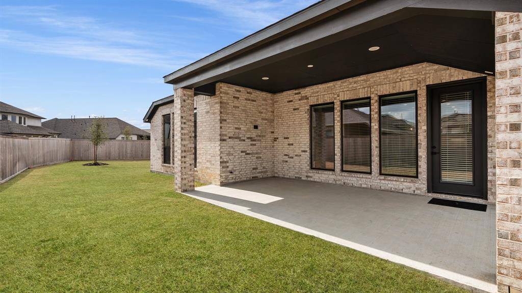 Large back patio, notice the upgraded bronze window frames to compliment the exterior aesthetic.