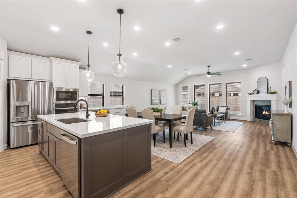Kitchen looking into dining and family space. Notice upgraded counter thickness, faucet, and deep stainless sink.