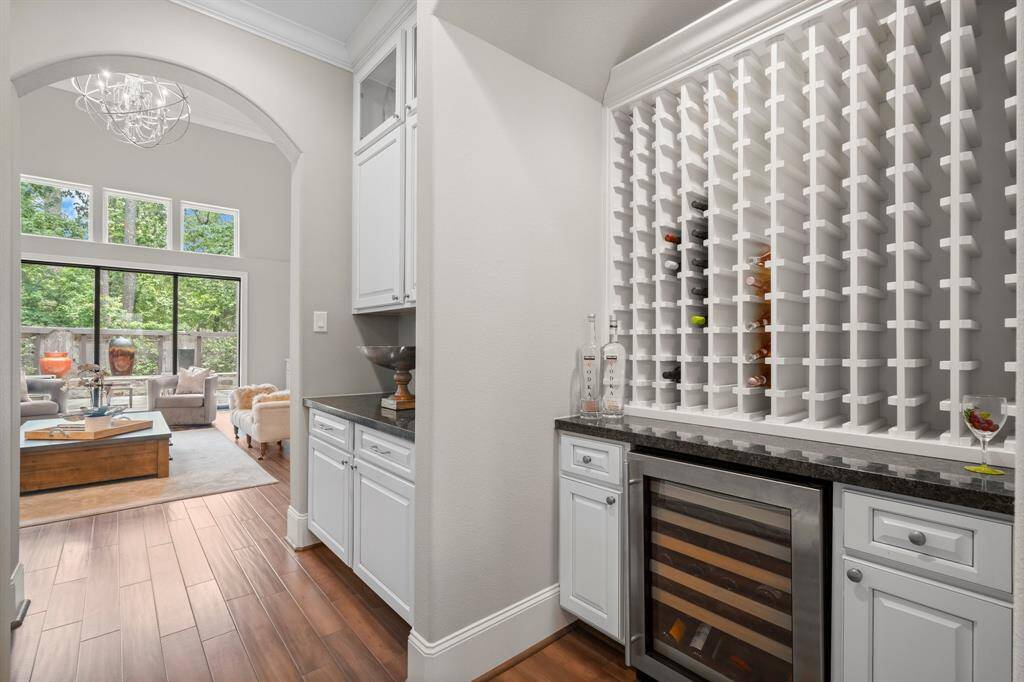 Perfectly positioned between the kitchen and formal dining room, the butler’s pantry marries elegance with utility. Floor-to-ceiling custom cabinetry meets a wine enclave crowned by a barrel ceiling, featuring dedicated racks for prized reds and a beverage refrigerator to keep whites perfectly chilled.