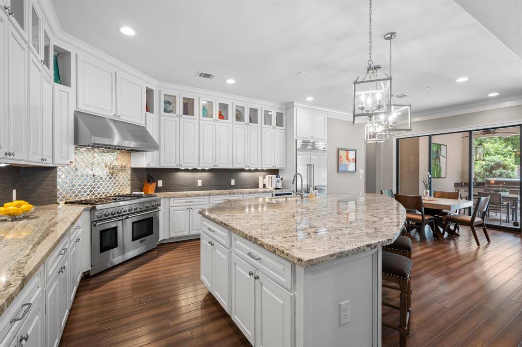 The kitchen is a stunning blend of modern elegance and function. A unique tile backsplash creates a refined aesthetic while the glass-front cabinets let you display your finest collectibles. The spacious walk-in pantry near the butler’s pantry offers exceptional storage.  The large sink with pull-out sprayer and built-in soap dispenser makes clean-up a breeze. A true chef’s kitchen designed for everyday living and grand gatherings alike.