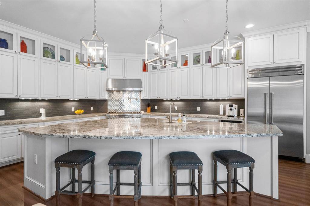 This stunning kitchen island serves as the focal point of the space, featuring eye-catching exotic pendant lighting, abundant cabinetry and open shelving for effortless organization, and generous prep space for the home chef. Perfect for hosting, it transitions seamlessly from a holiday buffet to an elegant happy hour spread—blending function with sophisticated style.