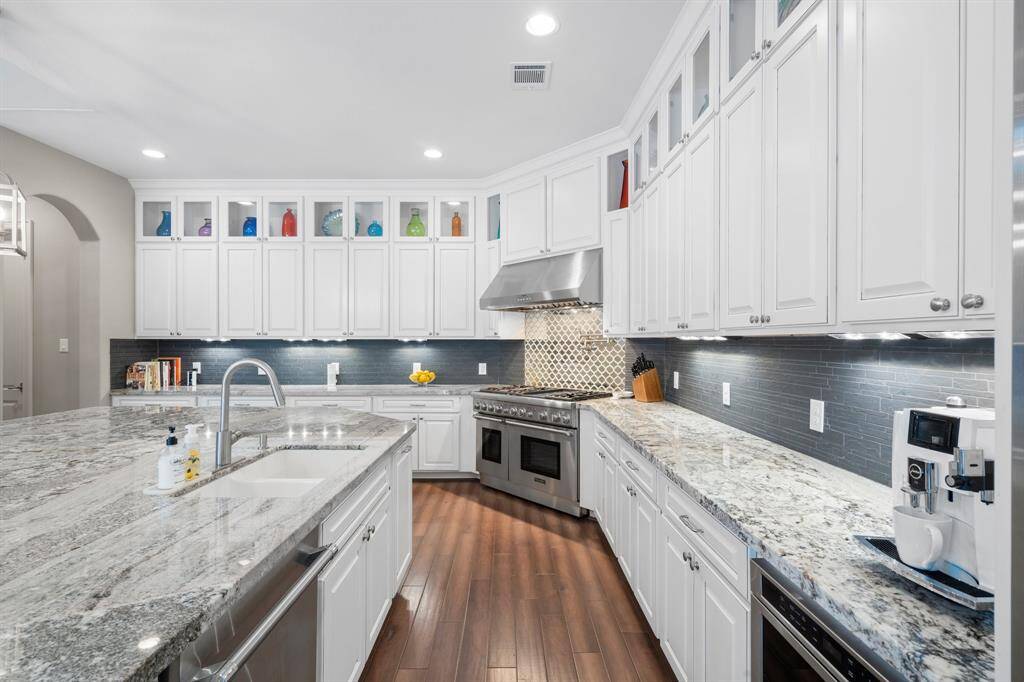 A pristine showcase of elegance and function, this extraordinary kitchen features top-of-the-line stainless steel Thermador appliances, including a 6-burner range with stainless steel vent hood and griddle, double ovens, microwave, dishwasher, and sub-zero refrigerator. Rich wood cabinetry offers abundant storage, complemented by sleek granite countertops. Designed for both gourmet cooking and sophisticated entertaining, this kitchen is truly the heart of the home.