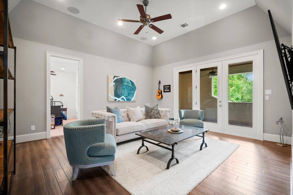 Step into the ultimate oversized game room—designed for fun and relaxation. Enjoy wood-look tile flooring, a stylish cove ceiling, surround sound speakers, ceiling fan, and abundant natural light from large French doors. All audio and video equipment throughout the house will stay.