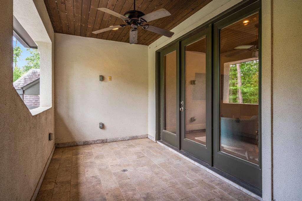 Just off the game room, second-floor occupants can enjoy their own private balcony—an inviting outdoor retreat with travertine tile flooring, recessed lighting, and a ceiling fan for year-round comfort. This elevated space offers serene views of the surrounding woods and beautiful morning sunrises, perfect for unwinding in style.