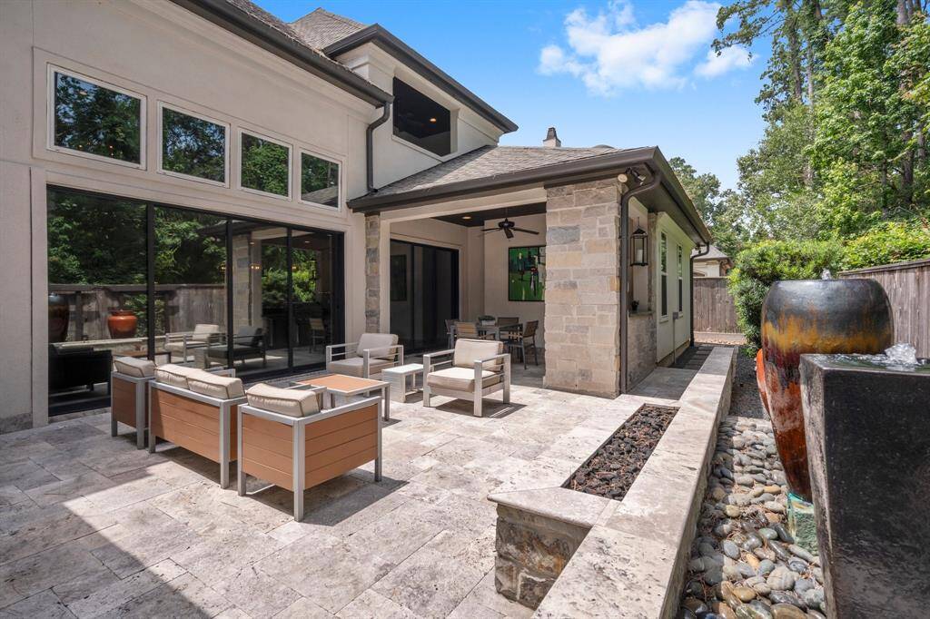 Before stepping inside, take a peek at this stunning backyard! Enjoy a covered porch with elegant travertine flooring, an outside Kitchen featuring Coyote appliances & beverage refrigerator, and a spacious patio featuring three bubbling water features and a fire feature. All backing to a wooded reserve for quiet solitude.