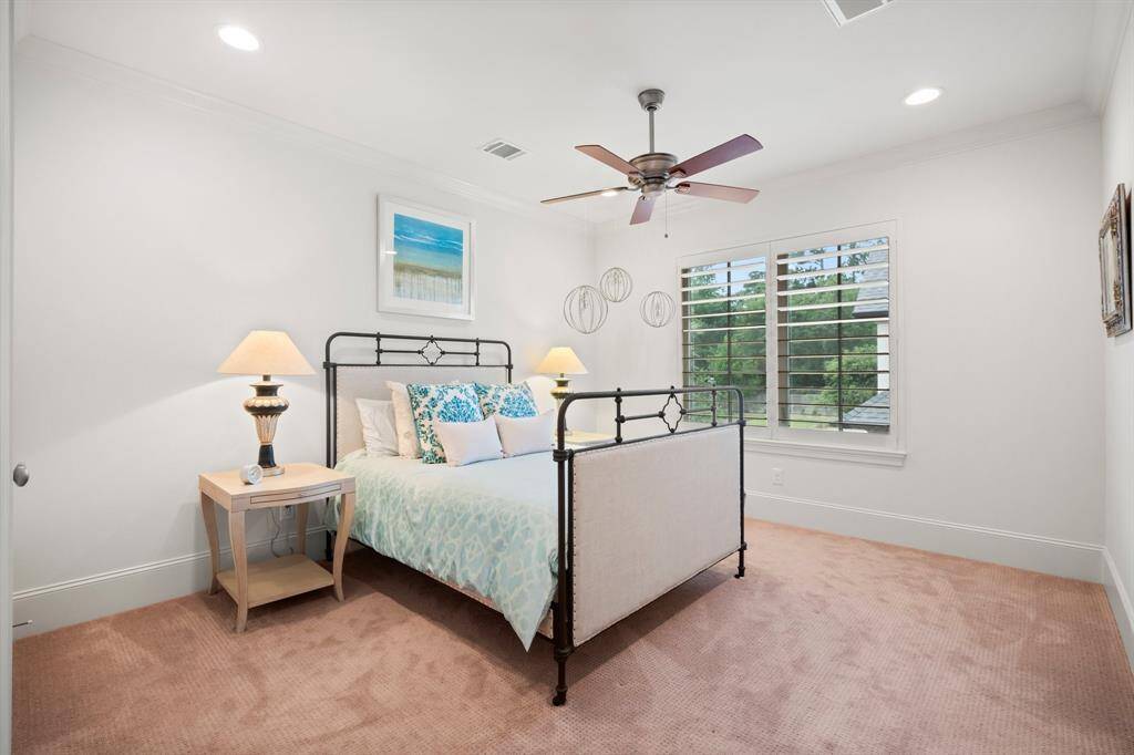 Another secondary bedroom offers lush carpeting, recessed lighting, crown molding, large walk-in closet with built-in shelving, sunny double window with 5” planation shutters, and ceiling fan.