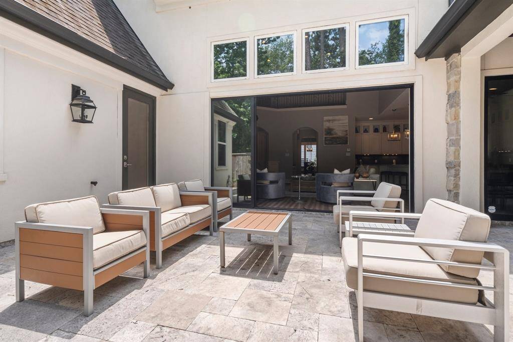 The expansive outdoor patio serves as an exceptional extension of your living space—ideal for entertaining. A full wall of sliding glass doors opens effortlessly, inviting guests to flow freely between indoor comfort and open-air gatherings.