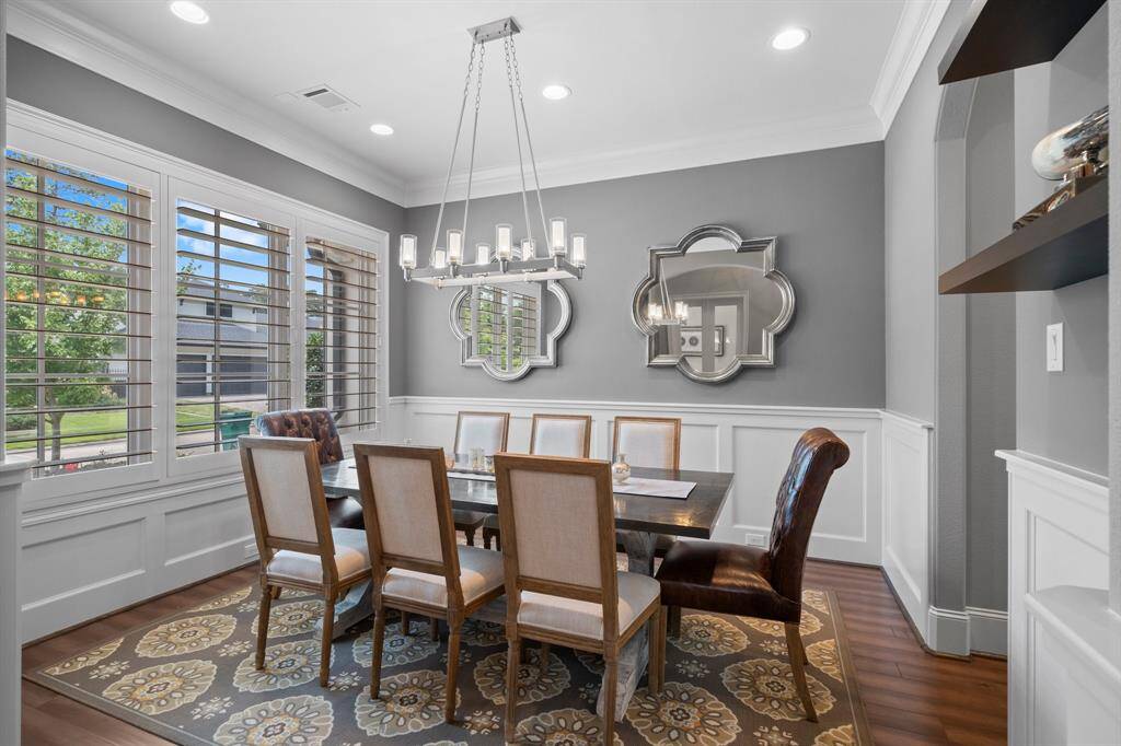 Gather your guests and celebrate in this stunning Formal Dining Room, designed for both grandeur and comfort. It features wood-look tile flooring, elegant wainscotting, three windows with 5’ plantation shutters for natural light, 9’ baseboards, triple crown molding, recessed lighting, and a designer chandelier. There is also a butler’s pantry area leading to the kitchen featuring a wine area and cabinets for additional storage.