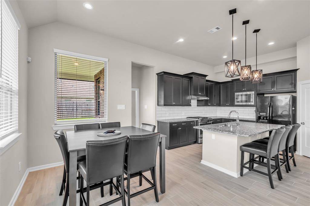 The dining area sits right next to the kitchen and is brightened by large windows that let in plenty of natural light.