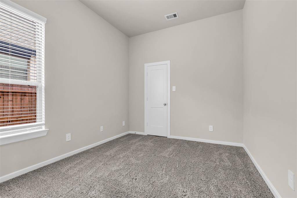 This secondary bedroom features carpeted floors and a window, providing a blank space for you to customize and make your own.