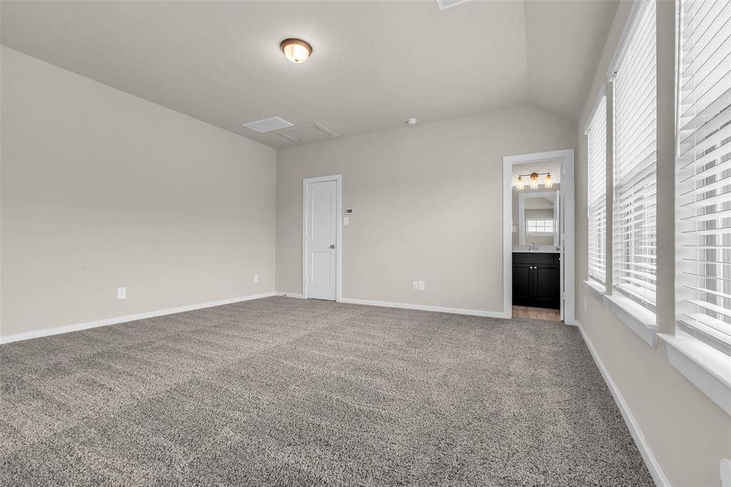 This spacious upstairs loft can easily be converted into a fourth bedroom. It includes an en suite bathroom and large windows that let in plenty of natural light, and carpeted floors for added comfort.