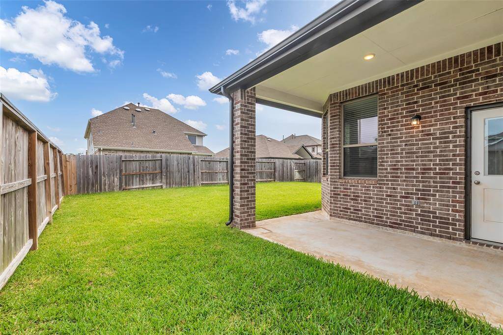 Welcome to the backyard, which includes a covered patio—great for outdoor meals or relaxing in the shade.