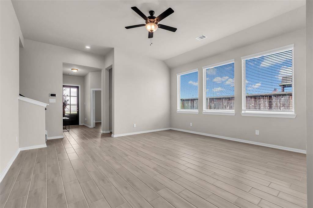 From this angle, the living room provides a welcoming space with a clear view of the front entrance and staircase, giving the home an open and connected feel.