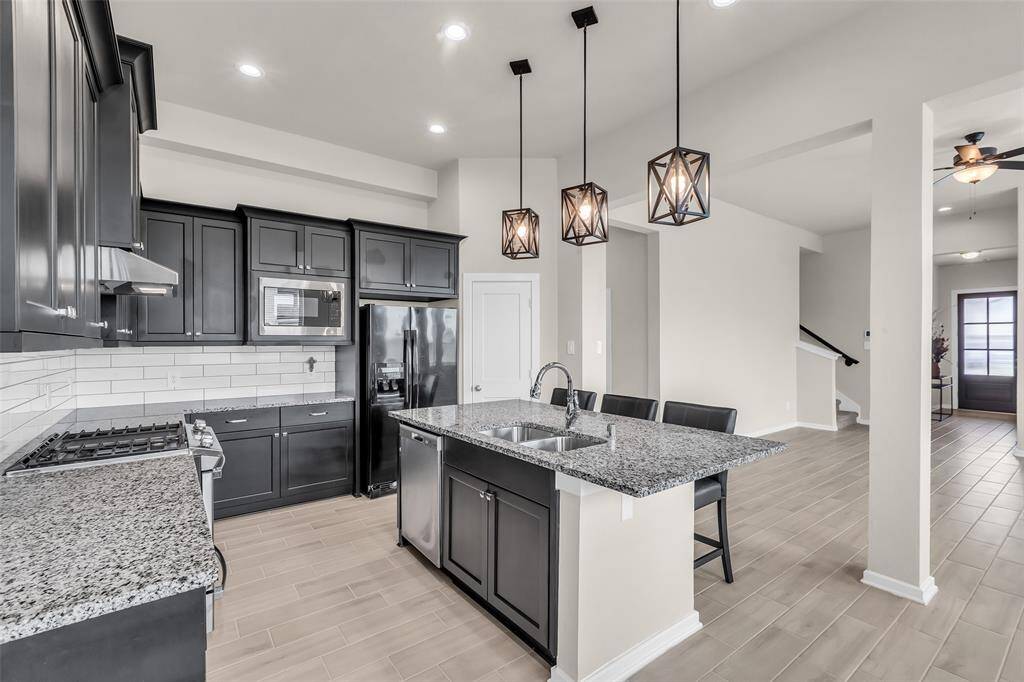 The kitchen island features a built-in sink and doubles as a convenient breakfast bar, perfect for casual meals and gatherings.