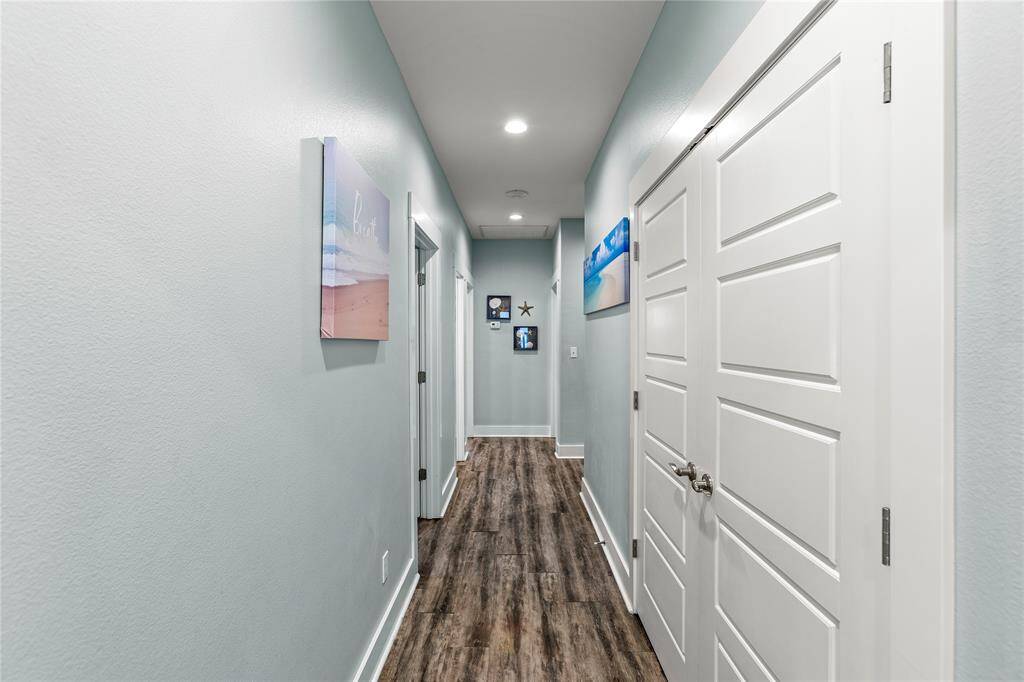 Hallway leads to the four secondary bedrooms on the first floor and laundry room on the right