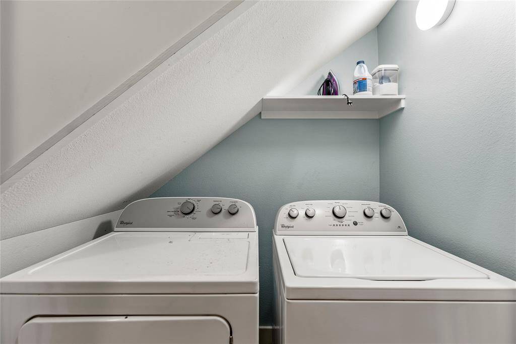 Laundry room fits a full-size washer and dryer under stairwell
