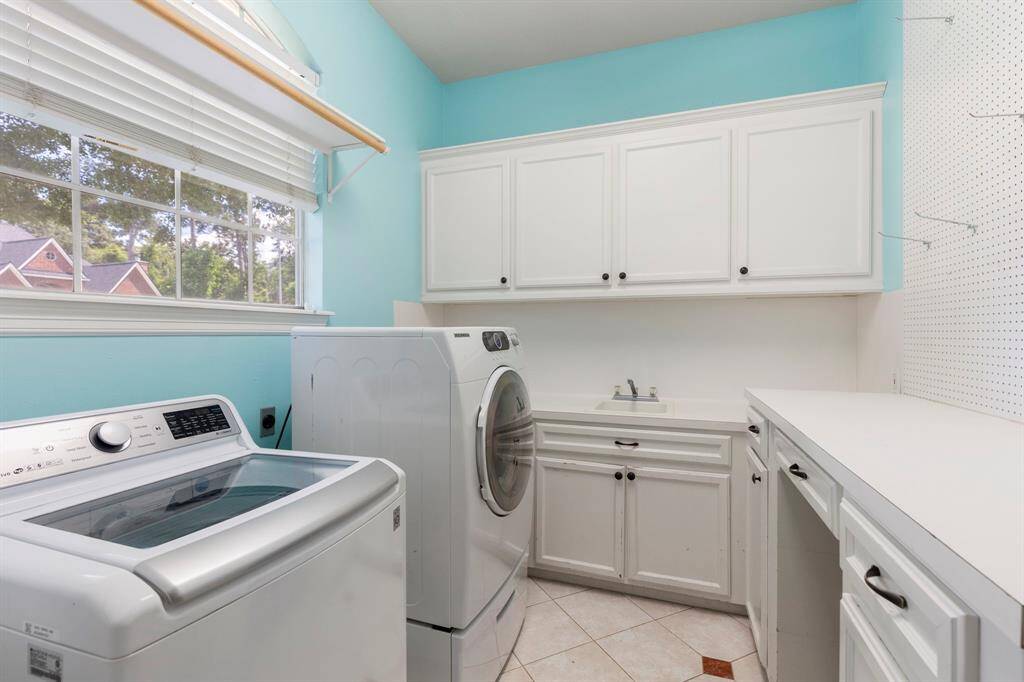 The utility room has a utility sink and lots of storage as well as a craft table.