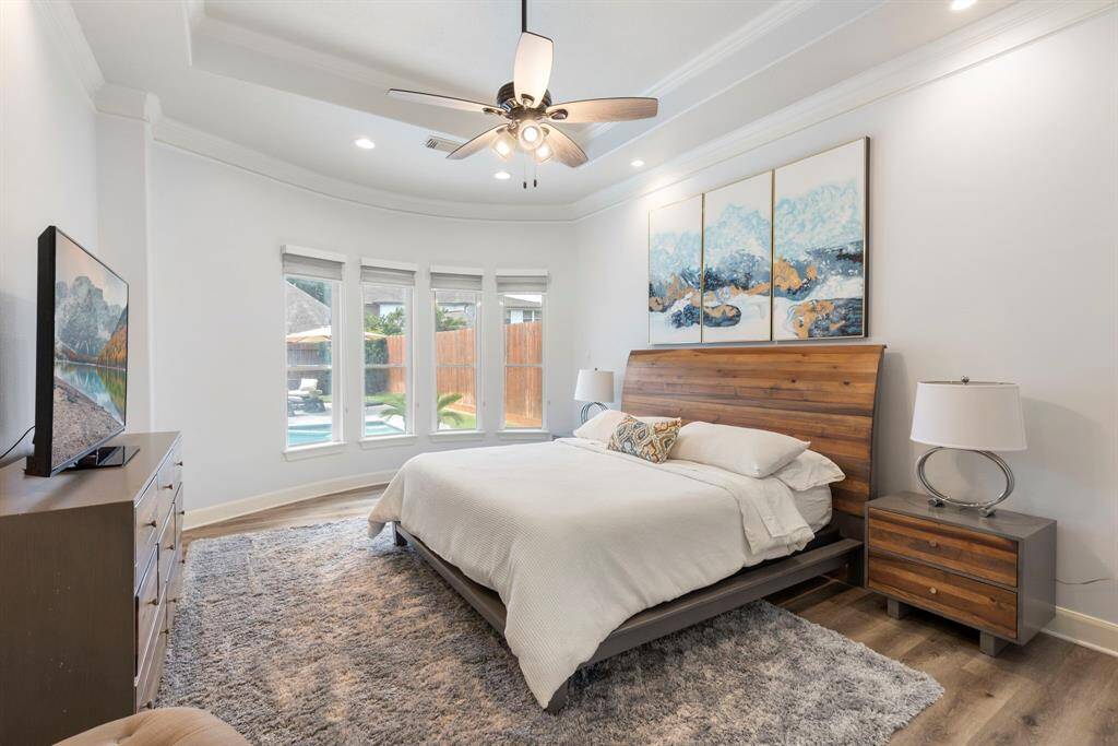 The luxurious primary suite is tucked away in the back of the house for privacy. It overlooks the pool area.