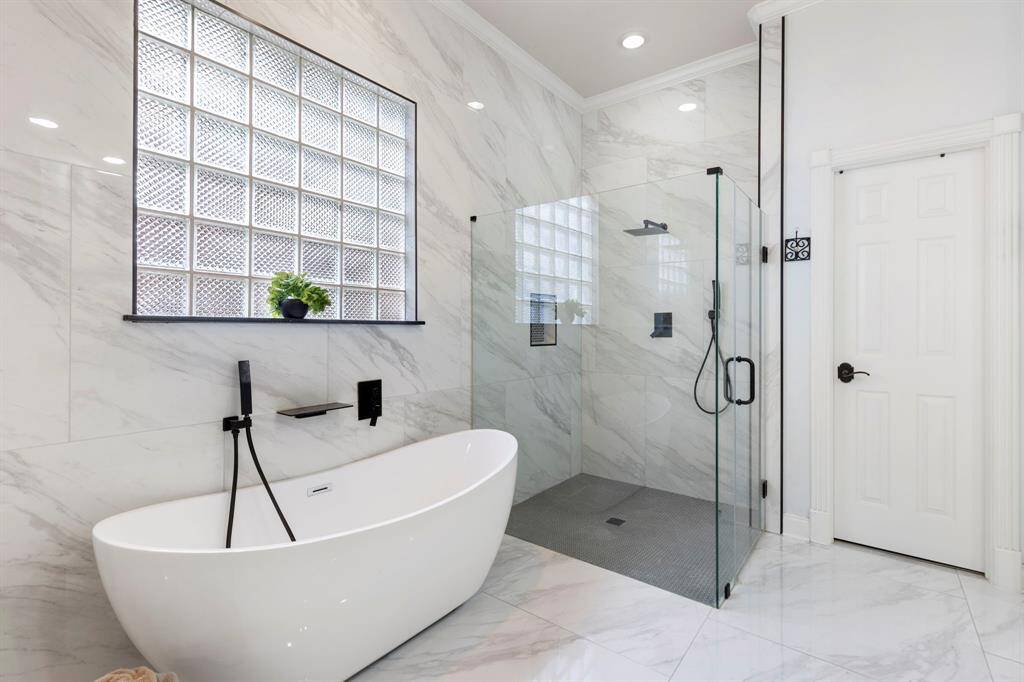 Newly remodeled primary en-suite bathroom, showcasing a stand alone tub and curbless shower.