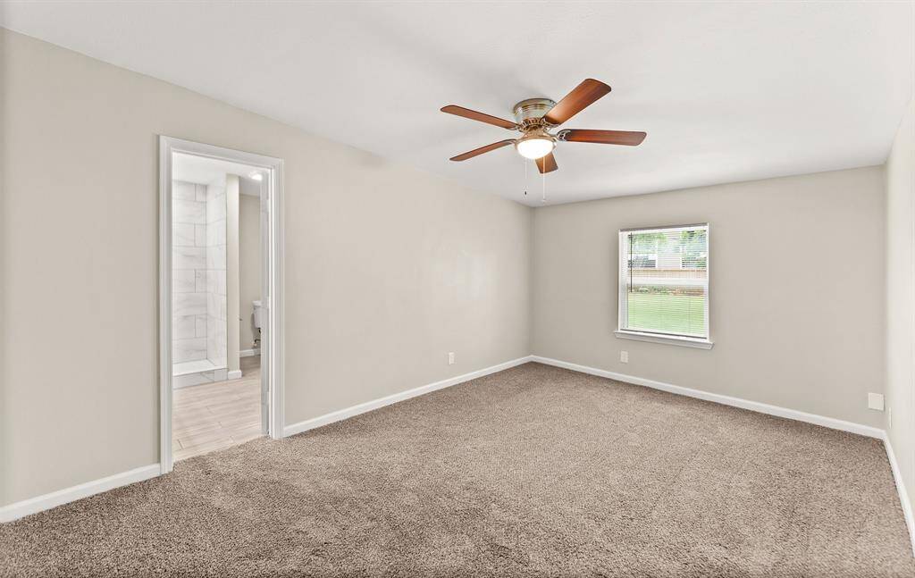 Spacious primary bedroom featuring a stunning walk-in shower and sleek modern vanity