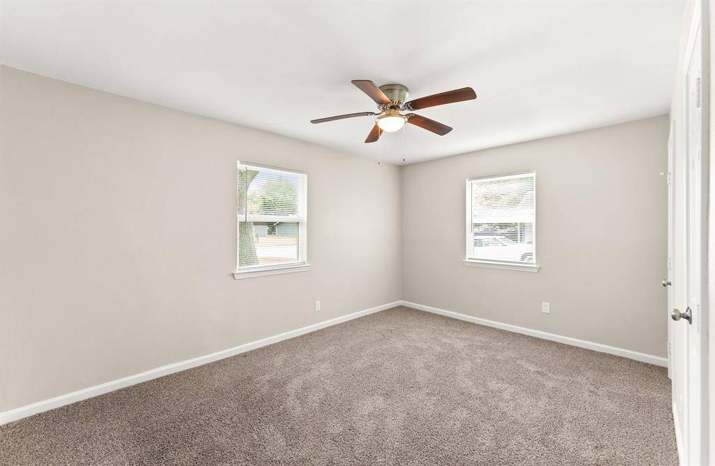 Bright bedroom featuring plush carpeting, neutral walls, and ample natural light—perfect for a cozy retrea