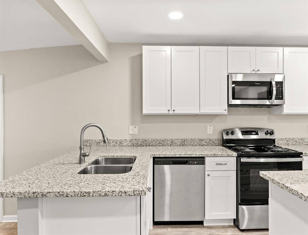Sleek granite countertops enhance the kitchen's modern elegance