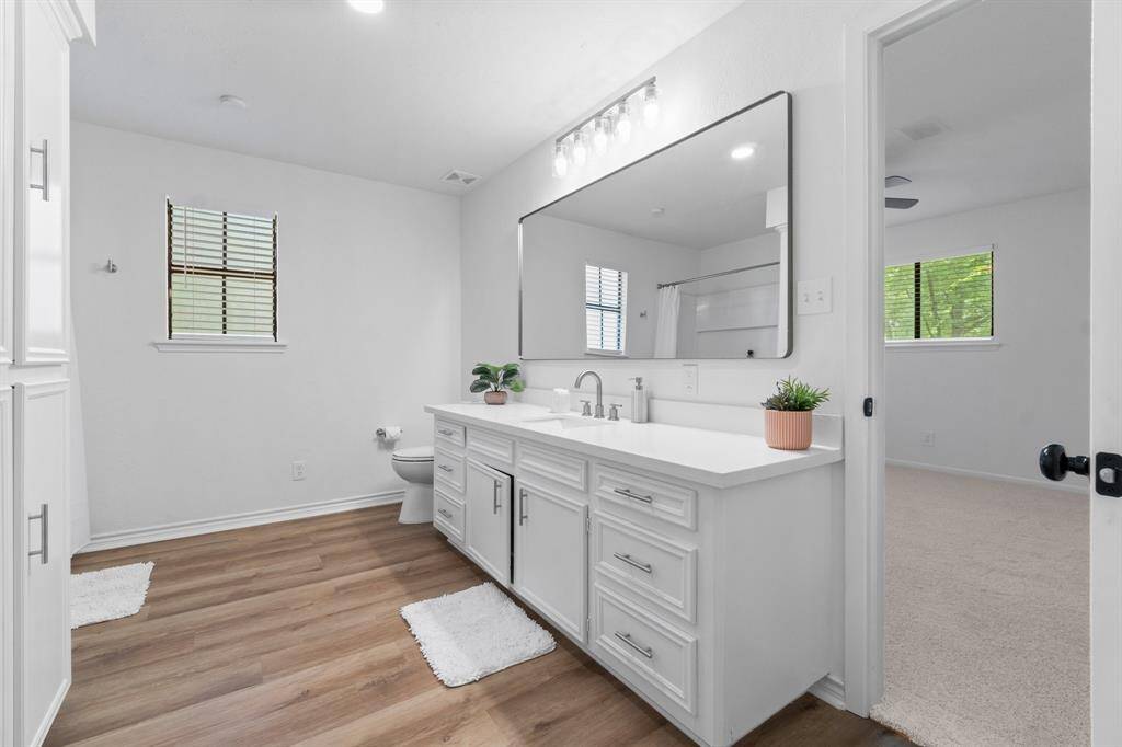 Spacious en-suite bath with newly imagined vanity with quarts countertop and updated mirror.