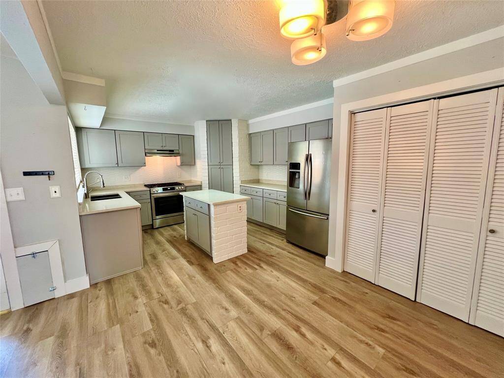 Kitchen elegantly appointed with quartz counters. Light and bright, chef-ready.