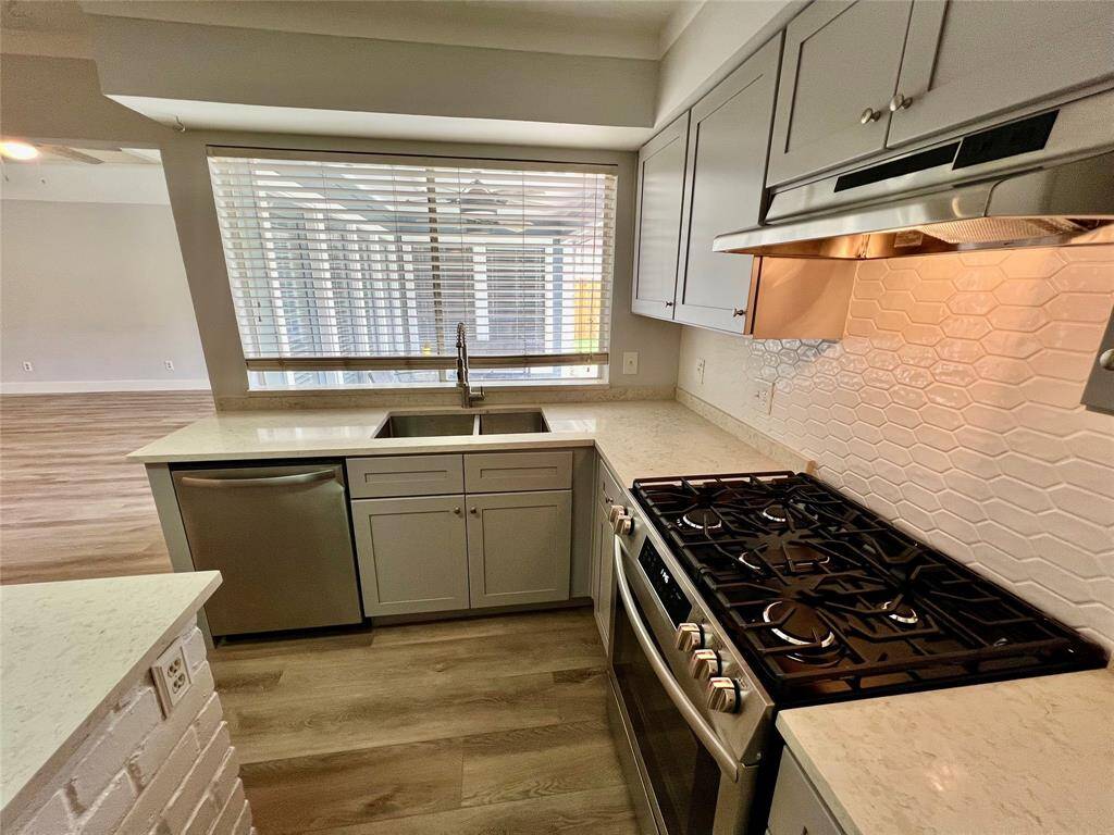 Five-burner gas range, stainless dishwasher, under-mount sink overlooking the backyard. Custom backsplash adds beauty.